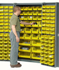 Built Tough Deep Door Bin Cabinet With 132 Yellow Plastic Storage Bins featuring a user accessing storage bins for organized workshop gear.