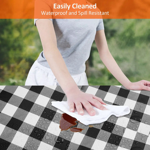 Person wiping a black and white checkered table cover to show Six Foot Picnic Table And Bench Cover Set Waterproof Windproof Elastic Tablecloth Fits 72 By 30 Inches Tables And 12 By 72 Inches Benches Three Pack With Table Cover And Bench Covers Black White Checkered Outdoor Camping Gear. Easily Cleaned Waterproof Spill Resistant text is visible at the top.