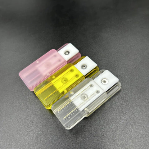 Pink Ding Ding Fidget Slider For Adults Kick Stress To The Curb With This Grab And Go Everyday Carry Gadget in pink, yellow, and clear.
