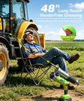 Man relaxing beside tractor with Cordless 12000 PSI Electric Grease Gun Kit, dual batteries, hose attached, in a field.