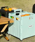 MACOPRO green plastic folding utility cart with lid and four swivel wheels, front view