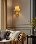 PENACINY Battery Operated Rattan Wall Sconces Set of 2 mounted on wall beside a cozy sofa with decorative pillows.