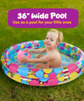 Child playing in a 36-inch colorful inflatable pool, part of the Duck Pond Matching Carnival Game For Kids Kid Friendly Inflatable Pool Play Set With 20 Plastic Ducks Featuring Number Pairs Totally Fun Backyard Water Memory Game For Birthday Parties Field Day And Outdoor Fun.