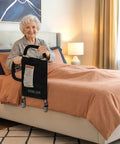 Senior using Dual Handle Bed Rail with Padded Grips and Storage Pocket, fits twin to king beds, black