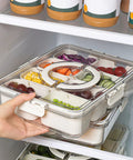 Two Pack Divided Snack Box With Clear Lid And Handles Portable Charcuterie Tray For Parties And Picnics in a fridge with veggies
