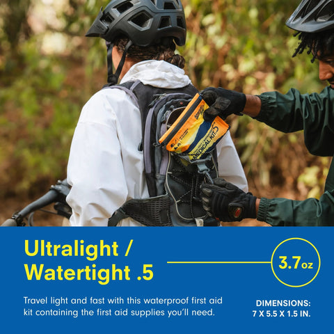 Adventure Medical Kit Ultralight/Watertight First Aid Kit .5 orange inserted into a hiker's backpack pocket outdoors