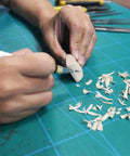 Person using 45mm Rotary Cutter And Precision Knife Set For Art Quilting And Crafting With 12 Bonus Blades Pro Grade Ergonomic Aluminum Handle Anti Slip Grip Safe Retracting Blade For Precise Clean Cuts on wood piece.