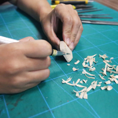 Person using 45mm Rotary Cutter And Precision Knife Set For Art Quilting And Crafting With 12 Bonus Blades Pro Grade Ergonomic Aluminum Handle Anti Slip Grip Safe Retracting Blade For Precise Clean Cuts on wood piece.