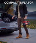 Man carrying Beefy 12V Double Cylinder Tire Inflator with car trunk open, showcasing easy portability for road use.