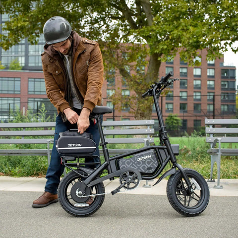 Man adjusting Foldable Electric Bike With Carry Handles Portable 350W Pedal Assist Twist Throttle Up To 15.5 MPH 14 Inch Tires