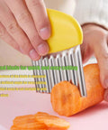 Front view of yellow-handled stainless steel crinkle cutter slicing a carrot on a pink cutting board