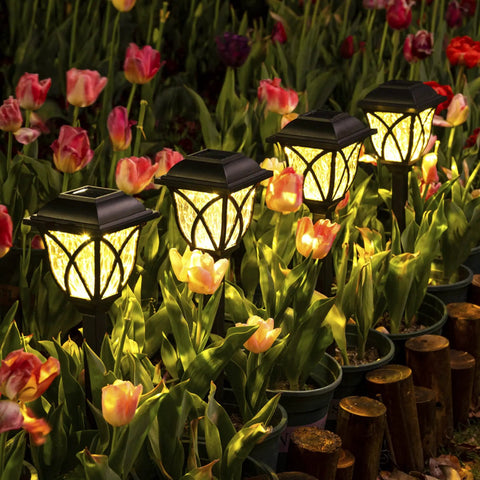 6 Pack Solar Pathway Lights Outdoor LED Garden Lights illuminating a garden walkway among tulips at night with a warm glow.