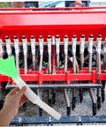 Hand holding Adjustable Seed Planter Tube Kit for Even Seed Spreading in front of farm machine in corn field