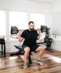 Man using Pro 100 Straight Bar For Adjustable Dumbbell System Convert Your Dumbbells Into A True Barbell in home gym setup