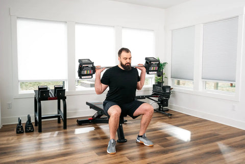 Man using Pro 100 Straight Bar For Adjustable Dumbbell System Convert Your Dumbbells Into A True Barbell in home gym setup