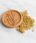 Terracotta Brown Sugar Saver Disc With Elegant Leaf Design And No Fuss Use beside softened brown sugar on white surface.