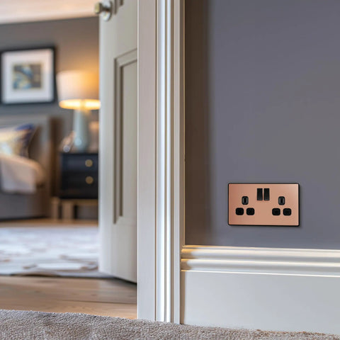 Modern Screwless Double Switched Wall Socket In Polished Copper Hella Easy Install Power Outlet For Home Renovation, mounted on a wall.