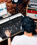 Person using Six Channel Bluetooth DJ Mixer Controller With LED Illumination And Digital Audio Mixing System in studio setup