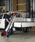 Worker using Powered Hand Truck Lift System With Hook, 309 Lb Lift Capacity, in warehouse near vehicle