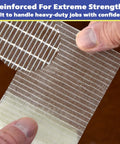 Close-up of hands peeling Workhorse Filament Tape 2 Inch By 30 Yards Reinforced Packing Tape With Strong Adhesive fibers.