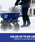Person using 80 lb salt spreader for ice melt and winter weather, walk behind residential broadcast spreader with spiked auger, adjustable baffles, 10 inch tires, coated steel frame, enclosed gears, weather resistant on snowy driveway