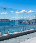 Top Tier Frameless Tempered Glass Railing Kit For Outdoor Decks, 44 Inch Height, showing clear glass panels and stainless steel posts near water.
