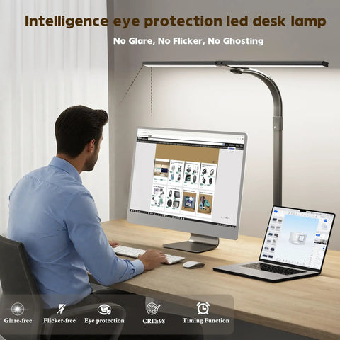 Man working at desk with Insanely Bright 24W LED Desk Lamp With Dual Swing Arm Heads, computer and laptop