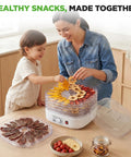 Mom and child using Five Tray Electric Food Dehydrator With Pro Airflow Circulation For Making Beef Jerky Dried Fruit And Homemade Dog Treats No Sweat Cleanup Countertop Build Great For Go Big On Healthy Snacks.