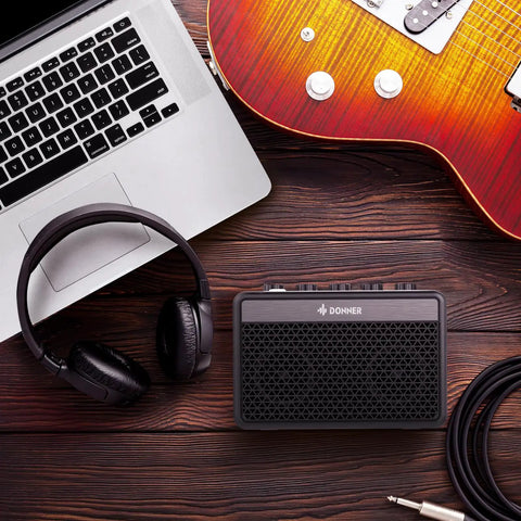 Portable 5W Mini Guitar Amp For Practice Jam Ready Compact Electric Guitar Amplifier With Built In Battery beside guitar and headphones