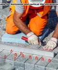 Front view of a construction worker kneeling with blue plastic horseshoe tile shims and red spacers used for leveling tiles.