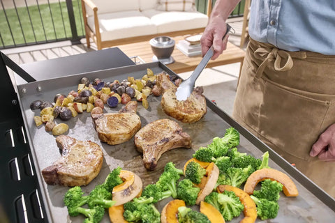 Chef using 24 Piece Griddle Tool Set With Storage Tote Stainless Steel Flat Top Grill Accessories to cook vegetables and meat.