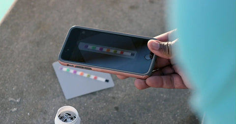 Person using smartphone to scan Six Way Pool Water Test Strips For Rapid Chemical Readings With Seamless App Sync To Keep Your Backyard Hangout Sparkling All Summer Long Without Any Headaches Or Sticker Shock From Costly Store Visits.