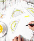 Four Piece Transparent Triangle Ruler Set With Protractor And Set Squares For Drafting And Geometry Drawing A Handy Multifunction Tool Kit For Designers Architects Engineers And Students. Transparent plastic rulers on paper