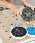 Person attaching ETS 150 Soft Sanding Pad For Heavy Duty Universal Use With High Temperature Durability StickFix Quick Change System