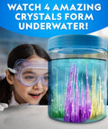 Girl observing underwater crystals forming in a jar from Five Types Crystal Growing Kit With Glow In The Dark Crystal Dinosaur Figure Underwater Crystals And Crystal Trees Plus Learning Guide A STEM Science Kit For Kids Totally Fun And Educational.
