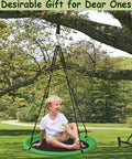 Child sitting on green 24 Inch Saucer Tree Swing Set For Kids And Adults, Adjustable Backyard Swing under a tree.
