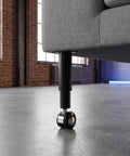 Adjustable Metal Desk Legs With Wheels Boss Level Mobility mounted on a sofa in modern home setting, showcasing swivel caster detail