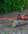 PWR Core 40 Brushless 40V Cordless Hedge Trimmer resting on a log, featuring 24-inch dual-action blade and 2.5Ah battery.