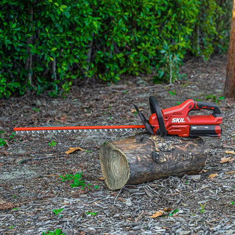 PWR Core 40 Brushless 40V Cordless Hedge Trimmer resting on a log, featuring 24-inch dual-action blade and 2.5Ah battery.