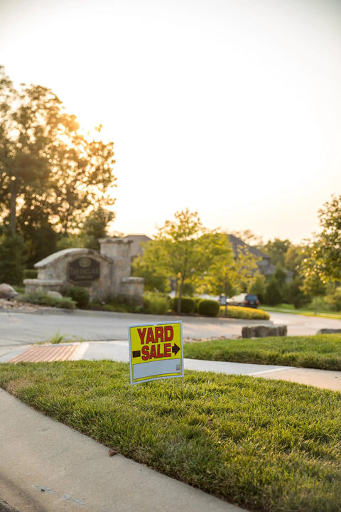 Double Sided Yard Sale Signs Kit 10 Pack Fully Assembled with Metal U Stake 22 by 14 Inches Bright Yellow Red Black High Visibility Made in USA Great for Curbside Garage Sale Setups shown on grassy curb.