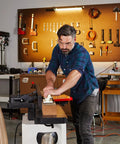 User operating a Badass Eight Inch Jointer Featuring Helical Cutterhead And Two Horsepower Motor for precise wood cutting.