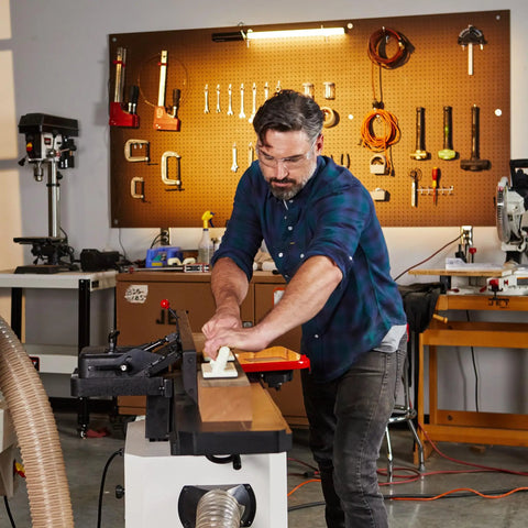 User operating a Badass Eight Inch Jointer Featuring Helical Cutterhead And Two Horsepower Motor for precise wood cutting.