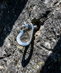 Close-up of installed stainless steel climbing bolt hanger on rock face, part of 16 Pcs Stainless Steel Climbing Bolt Hangers With 8 Pcs Expansion Bolts M10 Set CE Certified Anchor Point Gear For Rock Climbing Mountaineering And Caving Built Tough Rock Solid Gear For Your Rig.