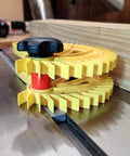 Heavy Duty Featherboard Stacking Spacer For Table Saw Resaw Setup, featuring yellow design and secure adjustment knob on a metal surface.