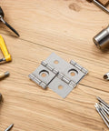 Retro Square Iron Cabinet Hinges And Lifting Brackets Set on wooden table with tools