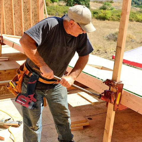Worker on construction site with Sturdy Tape Measure Holder And Drill Holster With Belt Clip attached to tool belt