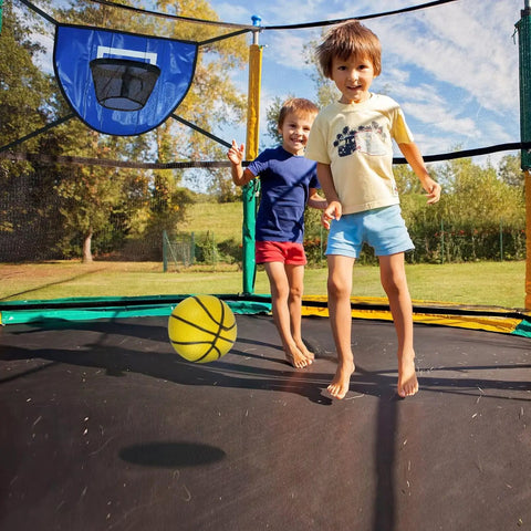 Children playing on trampoline with Trampoline Basketball Hoop With Pump And Mini Ball For All Ages, blue hoop attached, outdoors