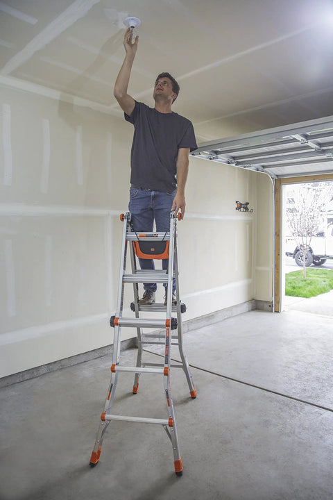 Man uses Cargo Hold Ladder Accessory Fabric Tool Pouch for multi-position ladders, attached on garage ladder