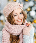 Pearl-embellished pink knit hat with matching scarf worn by a smiling woman