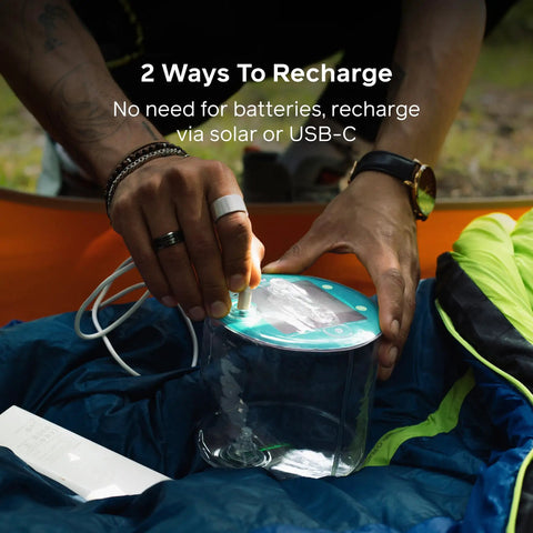 Person charging Luci Original Solar Inflatable Camping Lantern With USB C Recharge using USB-C cable outdoors